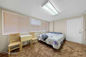 Bedroom with a textured ceiling and carpet
