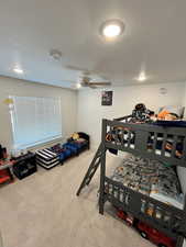 Bedroom featuring carpet flooring, a ceiling fan, and a textured ceiling