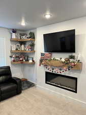 Carpeted living area with recessed lighting and baseboards
