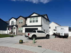 View of front facade with stucco siding, an attached garage, and concrete driveway