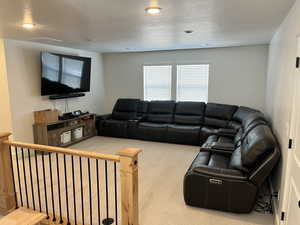Living area with carpet flooring, a textured ceiling, and recessed lighting