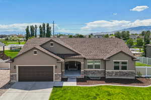 View of front of property featuring stucco siding, stone siding, roof with shingles, and an attached garage