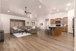 Living area featuring ceiling fan, wood finished floors, high vaulted ceiling, baseboards, and recessed lighting