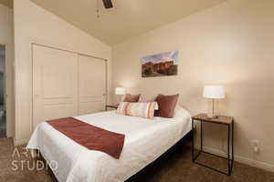 Bedroom featuring carpet floors, lofted ceiling, a closet, baseboards, and a ceiling fan