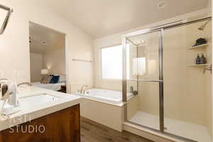 Bathroom featuring wood finished floors, vanity, a bath, and a shower stall