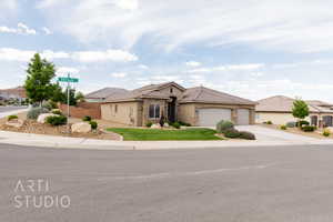 View of front of property featuring stone siding, a garage, driveway, stucco siding, and a tiled roof