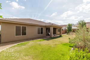 Back of property with stucco siding and a tiled roof