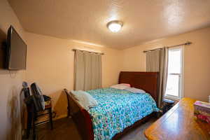 Bedroom featuring carpet floors and a textured ceiling