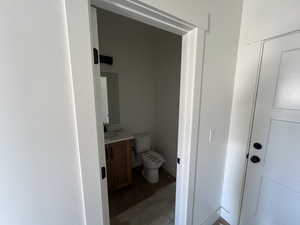 Bathroom featuring vanity, toilet, and wood finished floors
