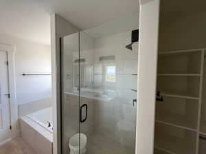 Bathroom with a garden tub, a shower stall, and toilet