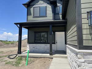 Property entrance featuring a porch and stone siding