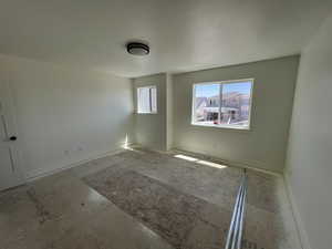Unfurnished room featuring baseboards and a textured ceiling