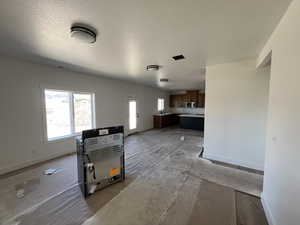 Unfurnished living room featuring baseboards and a sink
