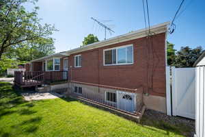 Rear view of house with yard,  wooden deck, and walkout basement