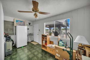 Office space featuring tile patterned floors, ceiling fan, and a textured ceiling