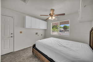 Bedroom with carpet floors, a textured ceiling, and a ceiling fan