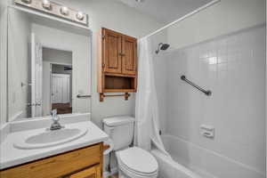 Full bath featuring vanity, shower / tub combo with curtain, and toilet