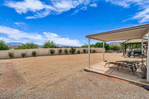 Fenced backyard with a gazebo, a mountain view, and a patio area
