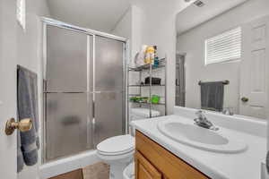 Bathroom with toilet, vanity, a shower stall, and tile patterned floors