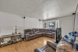 Living area featuring wood finished floors and a textured ceiling
