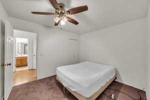 Bedroom with light carpet, a ceiling fan, baseboards, and a closet