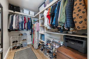 Walk in closet with wood finished floors