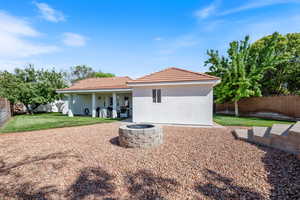 Rear view of house with a fire pit, stucco siding, a tiled roof, and a patio area