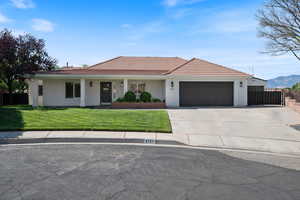 Ranch-style house with an attached garage, stucco siding, concrete driveway, and a tile roof