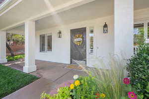 Entrance to property featuring stucco siding and a porch