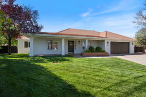 View of front of home featuring concrete driveway, stucco siding, an attached garage, and a tile roof