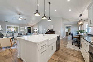 Kitchen featuring a sink, a ceiling fan, lofted ceiling, dishwasher, and open floor plan