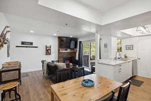 Dining room featuring light wood-style flooring, a large fireplace, recessed lighting, and baseboards