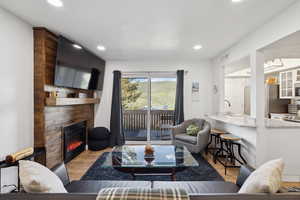 Living area featuring wood finished floors, a large fireplace, and recessed lighting