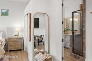 Bedroom featuring wood finished floors and a bar
