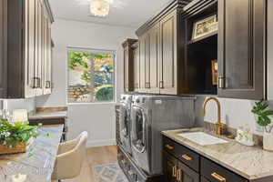 Laundry area with cabinet space, washing machine and dryer, baseboards, and light wood-style floors