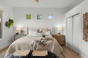 Bedroom featuring wood finished floors, baseboards, and a closet