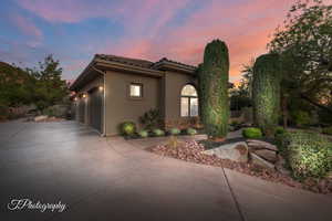 Mediterranean / spanish-style home with concrete driveway, a garage, stucco siding, stone siding, and a tile roof