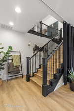 Stairs featuring wood finished floors, baseboards, and recessed lighting