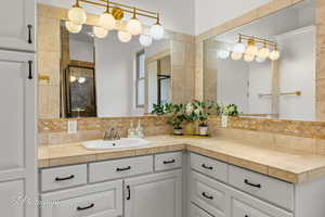 Bathroom with tasteful backsplash, vanity, and a stall shower