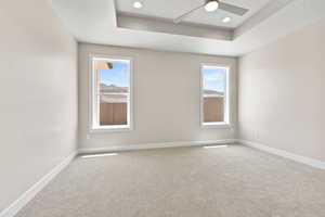 Unfurnished room featuring a tray ceiling, a ceiling fan, carpet, baseboards, and recessed lighting