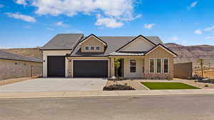 View of front of property with a garage, brick siding, concrete driveway, and a mountain view