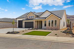 View of front facade featuring board and batten siding, concrete driveway, a garage, and brick siding