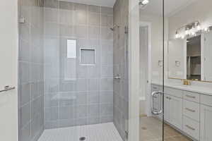Full bath with a shower stall, vanity, and tile patterned floors