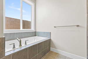Full bath with a garden tub, tile patterned flooring, and baseboards