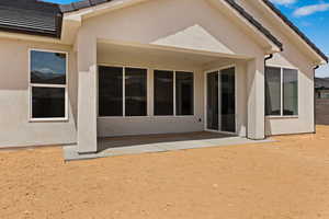 Rear view of house with stucco siding and a patio area