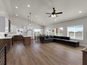 Living room with wood finished floors, ceiling fan, plenty of natural light, recessed lighting, and baseboards