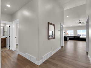 Hallway featuring wood finished floors, baseboards, and recessed lighting