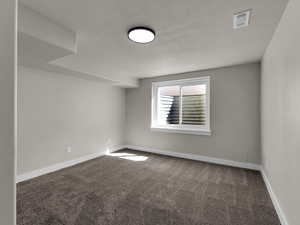 Empty room featuring carpet and baseboards