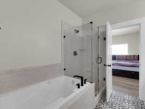 Ensuite bathroom featuring a stall shower, a bath, and tile patterned flooring