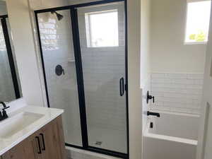 Bathroom featuring vanity, a bath, a shower stall, and plenty of natural light